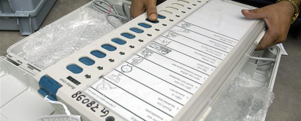 Polling officer checks an EVM at a distribution centre in Agartala