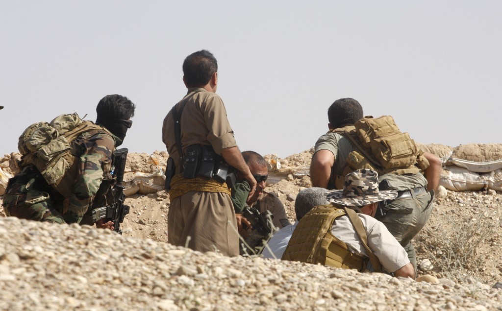 Members of the Kurdish security forces take cover during clashes with militants from the ISIL in Jalawla